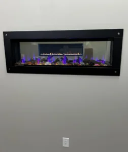 see-through electric fireplace in a wall with another fireplace behind it