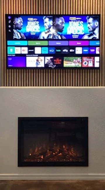 electric fireplace with tv on top mounted on acoustic wall panels